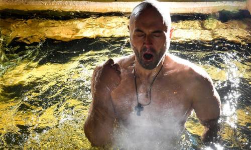 Un uomo si immerge nell'acqua gelata durante le celebrazioni dell'epifania ortodossa a Mosca, in Russia. 