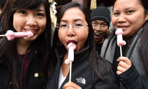 Alcune ragazze succhiano dei lecca lecca a forma di pene presso il Santuario Wakamiya Hachimangu di Kawasaki, un sobborgo di Tokyo