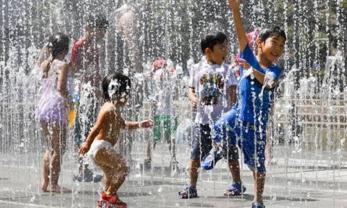 Un gruppo di bambini gioca fra i getti d'acqua in un parco vicino a Nerima,Tokyo